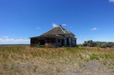 Abandoned house on field against sky