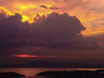 Scenic view of sea against cloudy sky at sunset