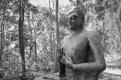 Statue of man in forest