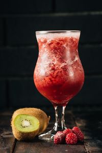 Close-up of red drink and fruits on table