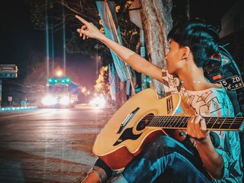 Man playing guitar at illuminated music concert