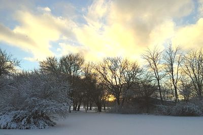 Snow covered landscape against cloudy sky