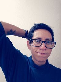 Portrait of smiling young man against wall at home