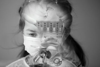 Double exposure of girl wearing mask and scientist working at laboratory