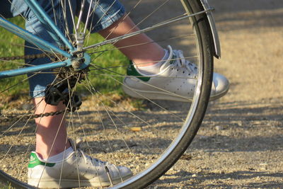 Low section of person with bicycle on road