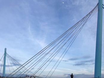 Low angle view of suspension bridge against sky