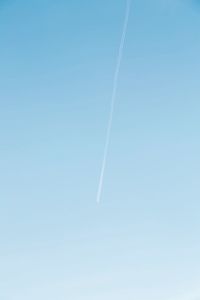 Low angle view of vapor trail against clear blue sky