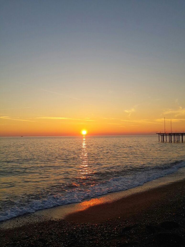 sea, horizon over water, sunset, water, beach, scenics, tranquil scene, tranquility, beauty in nature, sun, shore, orange color, idyllic, nature, sky, copy space, wave, clear sky, sunlight, sand