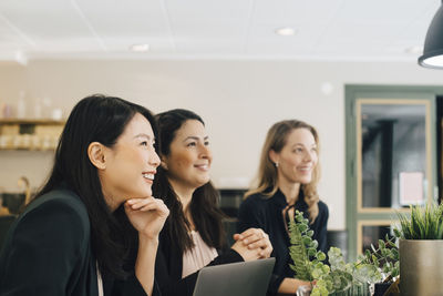 Smiling businesswomen sitting at conference table in meeting