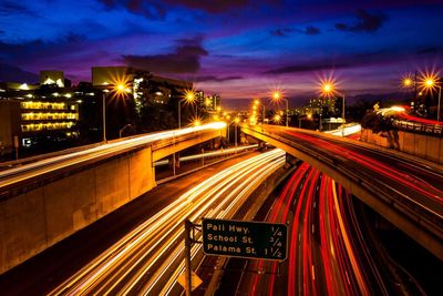 High angle view of information sign against multiple lane highway with light trails