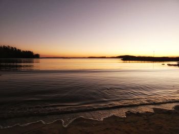 Scenic view of lake against clear sky during sunset