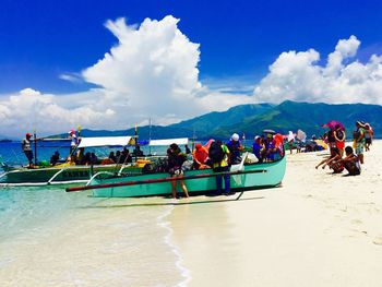 People at beach against sky