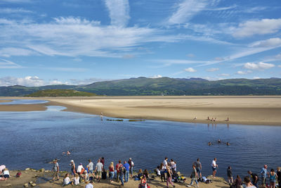 People at beach against sky