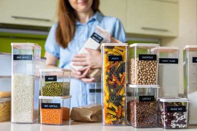 Midsection of woman holding food in container