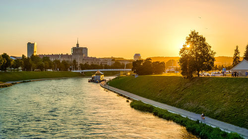 View of buildings at waterfront during sunset