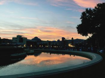 Reflection of buildings in river at sunset