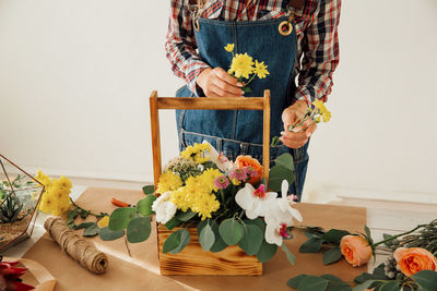 Flower vase on table against wall