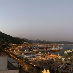 High angle view of illuminated buildings in city against clear sky