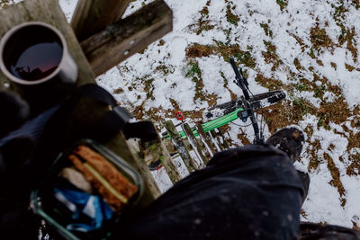 Low section of person with bicycle on snow