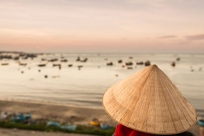 Rear view of person on beach against sky during sunset