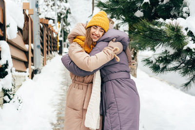 Woman wearing hat standing in snow during winter