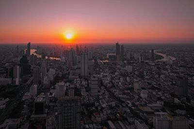 Aerial view of buildings in city during sunset