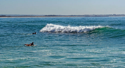 Man surfing in sea against clear sky