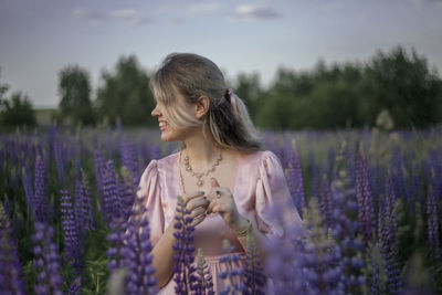 Young woman standing on field during rainy season