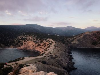 Scenic view of river by mountains against sky