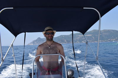 Man sitting in boat against sea