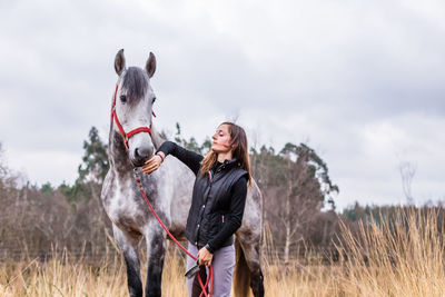 Side view of horse standing on field against sky