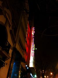 Low angle view of illuminated text on street at night