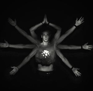 Close-up of young woman with arms raised