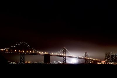 Suspension bridge over river at night