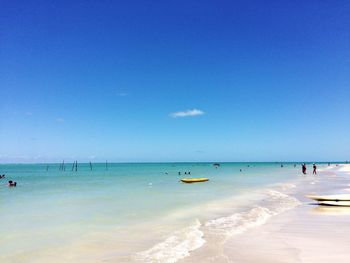 Scenic view of beach against clear blue sky