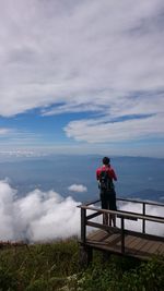Man photographing while standing at observation point against sky