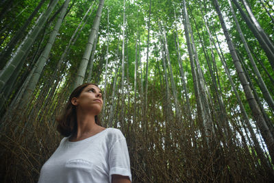 Young woman looking away in forest