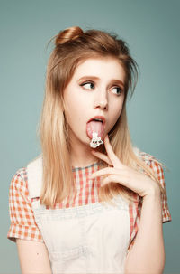 Portrait of young woman against wall