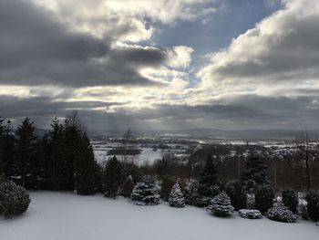 Scenic view of snow covered field against sky