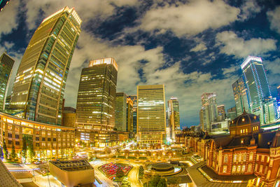 Illuminated buildings in city against sky