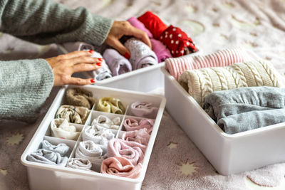 Cropped hands of woman arranging towels in container