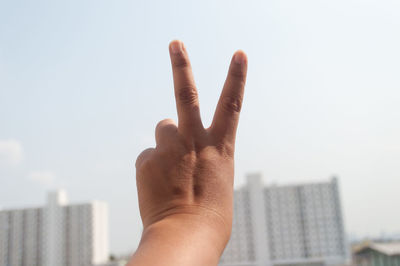 Close-up of childs hand making victory sign