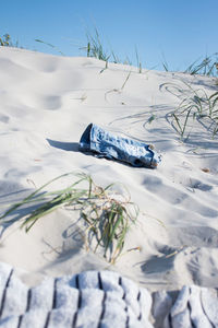 Close-up of jeans on beach 
