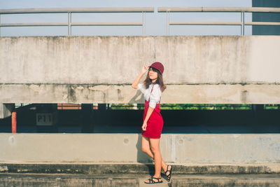 Full length of woman standing against wall