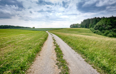 Empty road along countryside landscape