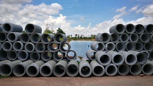 Stack of pipes against sky