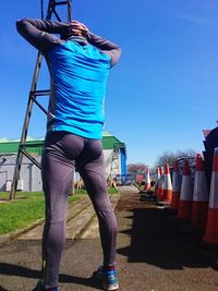 Rear view of woman standing against blue sky