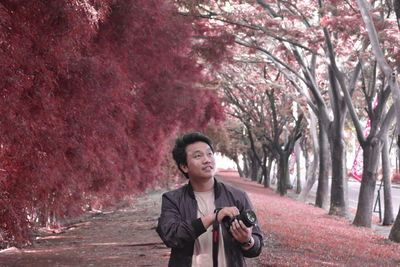 Portrait of smiling man standing against trees