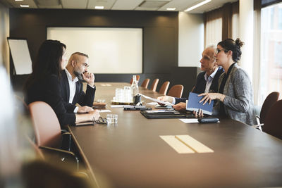 Confident lawyers planning over evidence at conference table in office meeting