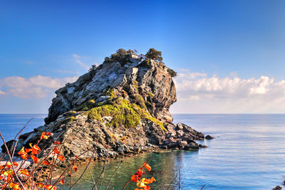 Rock formation on beach against sky